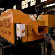 Close-up image of a Sweed CE513 strapping chopper machine operating in a warehouse setting