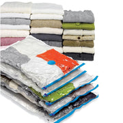 Stack of various sizes of vacuum storage bags with clothes visible inside them as well as clothes folded and stacked behind them on a white background