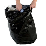a hand putting rubbish into a large black bin bag on a white background