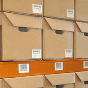 closeup of cardboard archive boxes stacked on a warehouse shelf.