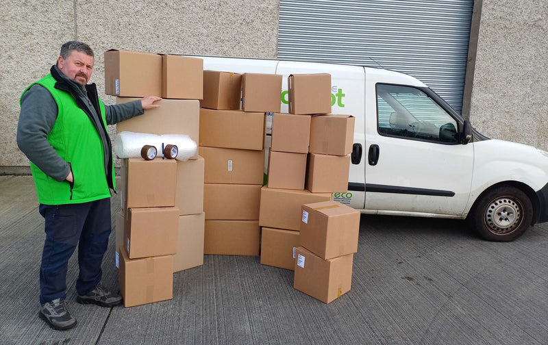 Bargain Moving Kit display of boxes and accessories in front of the Box Depot van and staff member standing beside it to show perspective