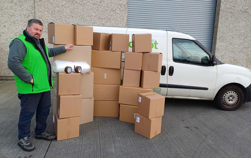 Bargain Moving Kit display of boxes and accessories in front of the Box Depot van and staff member standing beside it to show perspective