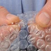 Hand pressing the bubbles of bubble wrap