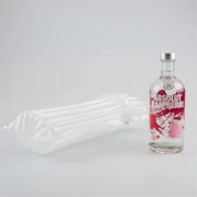 a bottle of vodka beside an inflated Bubl Single air cushioning pod on a plain background