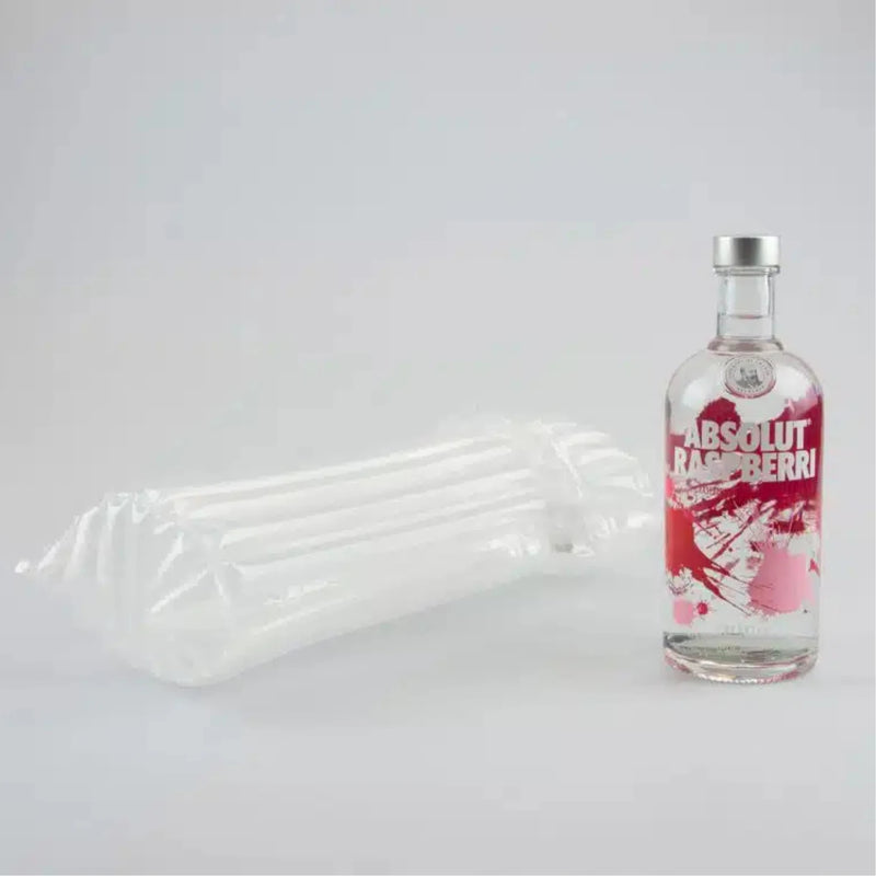 a bottle of vodka beside an inflated Bubl Single air cushioning pod on a plain background