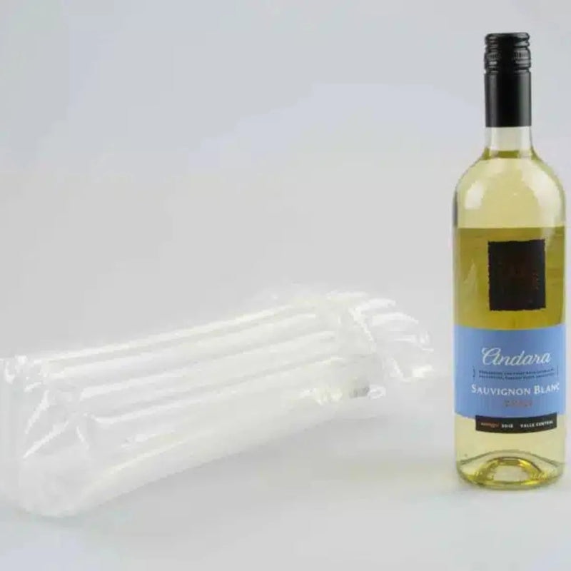 a bottle of white wine beside an inflated Bubl Single air cushioning pod on a plain background