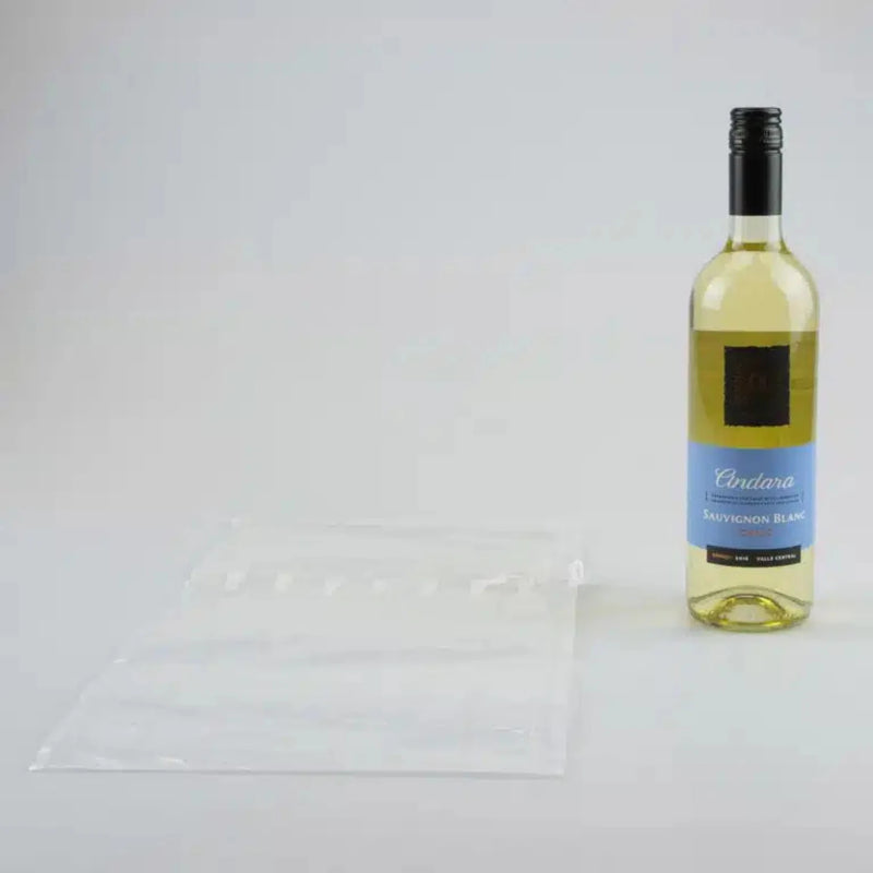 a bottle of white wine beside an uninflated Bubl Single air cushioning pod on a plain background