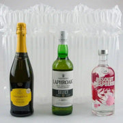 three bottles of prosecco, whiskey and voda in front of an inflated Bubl Triple air cushioning pod on a plain background