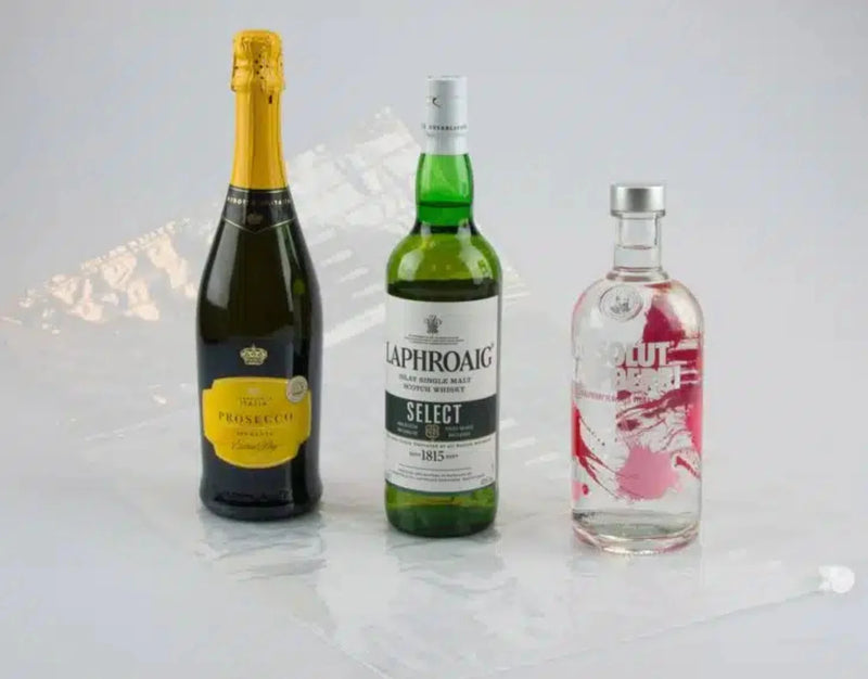 three bottles of alcohol in different sized bottles beside an uninflated Bubl Triple air cushioning pod on a plain background