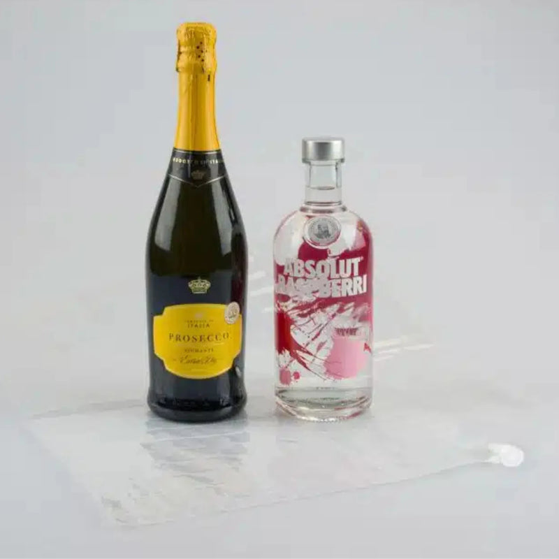 two bottles of Prosecco and Vodka beside an uninflated Bubl Double air cushioning pod on a plain background