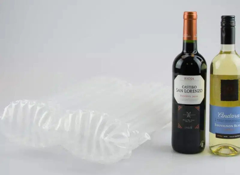 two bottles of wine beside an inflated Bubl Twin air cushioning pod on a plain background