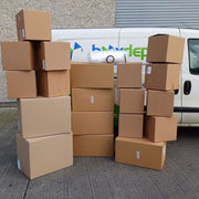 Budget Moving Kit comprising 19 cardboard boxes, bubble wrap, sealing tape and marker in front of the Box Depot van for perspective
