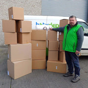 Budget Moving Kit of 19 boxes with bubble wrap, sealing tape and marker in front of the Box Depot van with man standing beside it for perspective