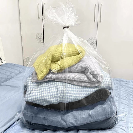 a clear bedding bag filled with clothes on top of a bed with a wardrobe in the background