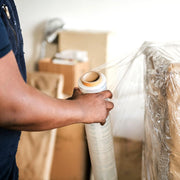 Man wrapping a pallet with clear pallet wrap in an industrial setting