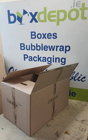 a large cardboard box on a table in front of Box Depot advertising