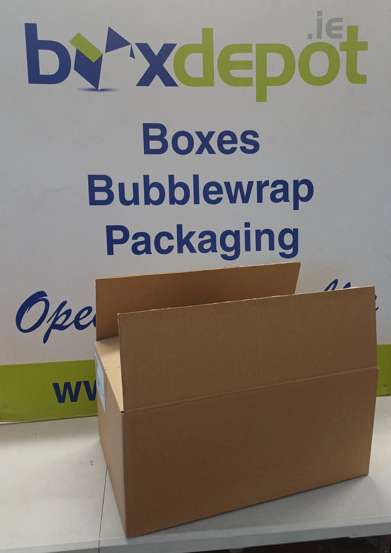 A brown cardboard box with its flaps open, placed in front of a ox Depot advertising board