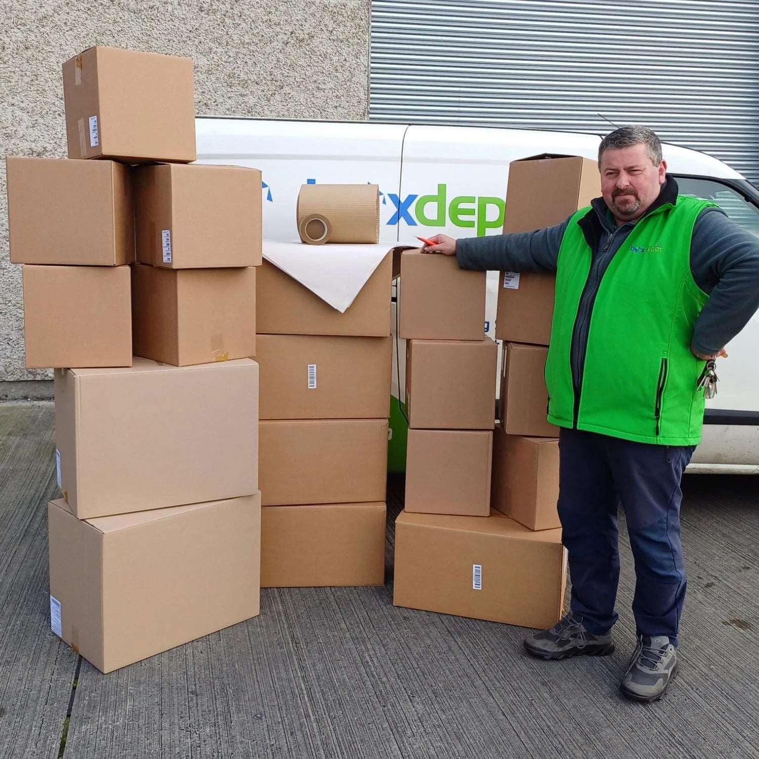 Eco Budget Moving Kit including 19 cardboard boxes, packing paper, corryboard and paper tape photographed beside a Box Depot employee and Box Depot van for perspective