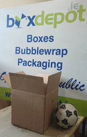 small single walled cardboard box beside a football in front of Box Depot advertising