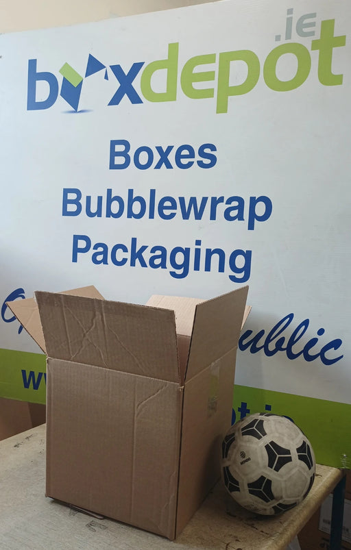 small single walled cardboard box beside a football in front of Box Depot advertising