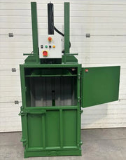 front view of a GE100 Cardboard baler with the upper door open in warehouse surroundings