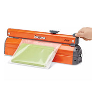 Hand using a Hacona C320 Heat Sealer to seal a green product in a clear bag on a white background