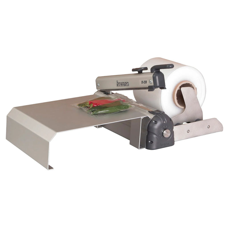 Hacona Inox Heat Sealer with roll dispenser and table top sealing a bag of fresh produce on a white background