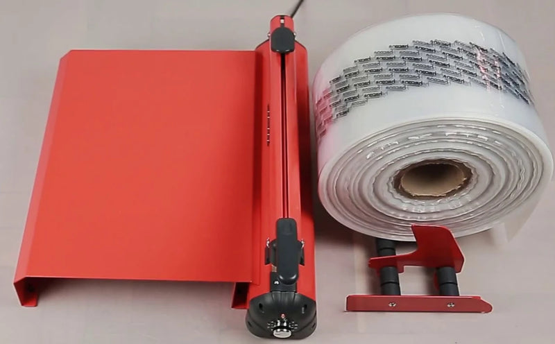 overhead view of an orange Hacona Heat Sealer with bag roll holder and modular table on a plain background