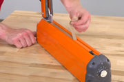 Person replacing a teflon strip on a Hacona Heat Sealer on a wooden table