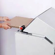 Hands feeding cardboard into a Kobra Desktop Cardboard Shredder