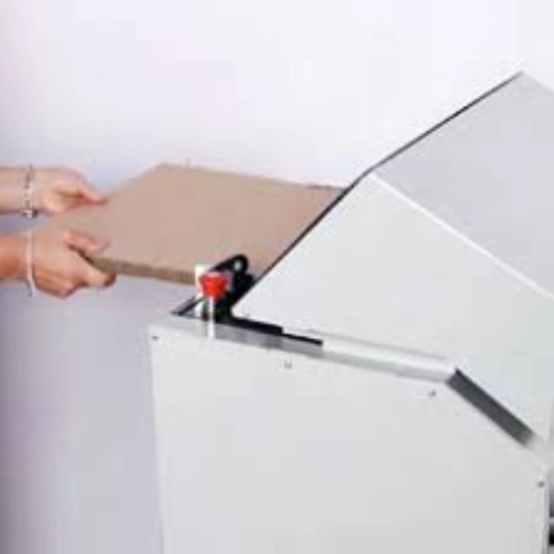 Hands feeding cardboard into a Kobra Desktop Cardboard Shredder