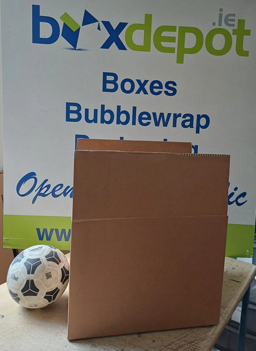image of medium single walled pre-loved cardboard box beside a football in front of Box Depot sign
