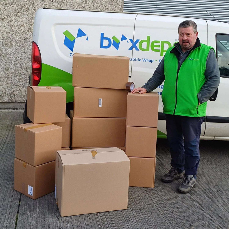 Mini Moving Kit with 13 boxes! and tape beside a man and the Box Depot van
