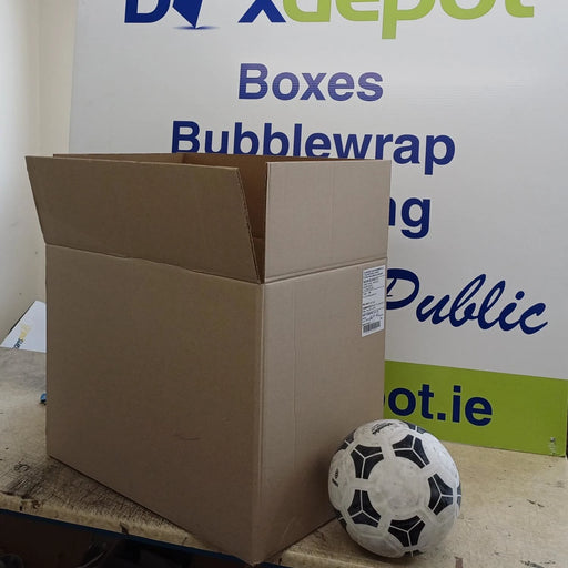 Large pre-loved once-used cardboard box beside a football in front of Box Depot advertisement
