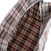 Closeup of an unzipped open plastic woven storage bag showing the interior on a white background