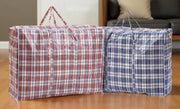 two large plastic woven storage bags on a wooden floor with a neutral wall and sofa in the background