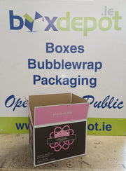 pink and black cardboard box in front of Box Depot advertising