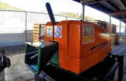 closeup of a Sweed CE450DDX Strapping Chopper being fed with metal pallet strapping outdoors in a warehouse environment