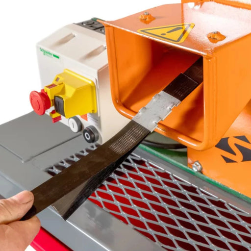 Close-up image of a Sweed CE510 strapping chopper machine with pallet strapping being fed through it