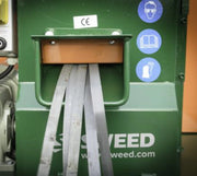 closeup of a Sweed CE510 Strapping Chopper being fed with plastic pallet strapping