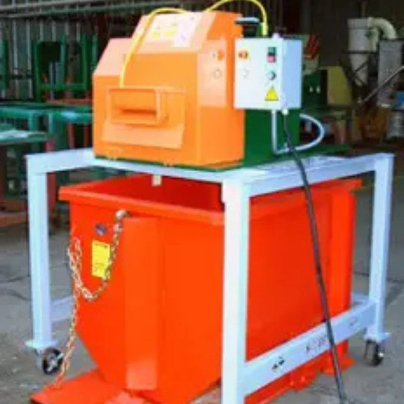 Sweed CE513 strapping chopper machine resting on a grey steel frame with a red skip bin underneath in a warehouse surroundings