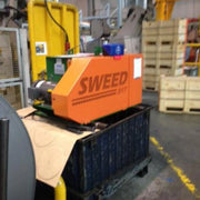 Image of a Sweed CE517XHD strapping chopper machine in a warehouse setting