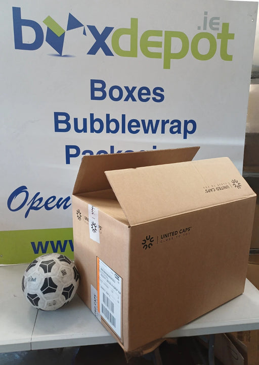 A brown cardboard shipping box placed in front of Box Depot advertisng and a soccer ball on a table