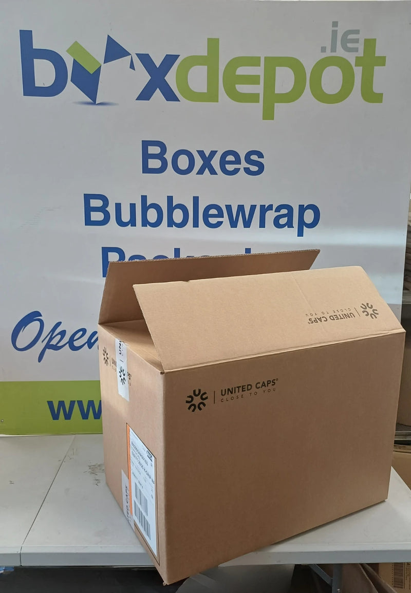 A brown cardboard box standing open on a white table in front of a Box Depot advertising sign.