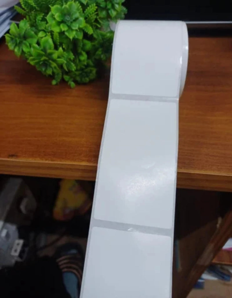 A roll of white address labels on a desk in an office environment