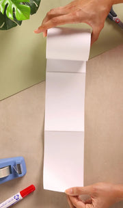 A woman unrolling some white address labels at a desk