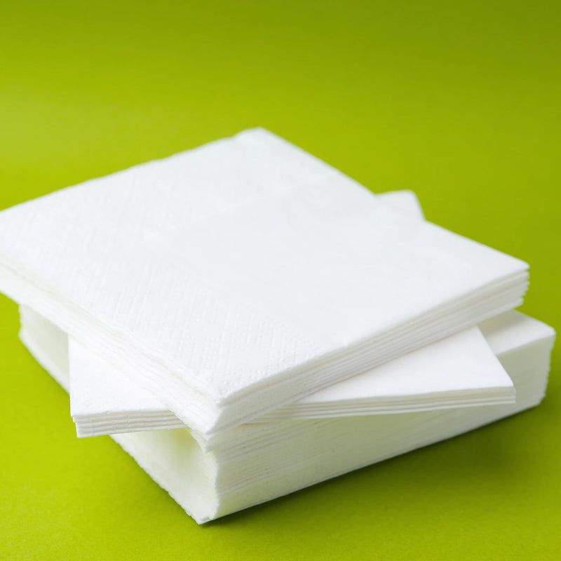 white packing paper stacked in a pile on a green background