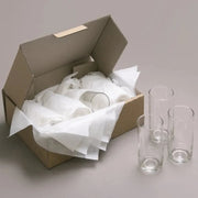 a set of drinking glasses wrapped in acid free tissue paper and packed into a cardboard box