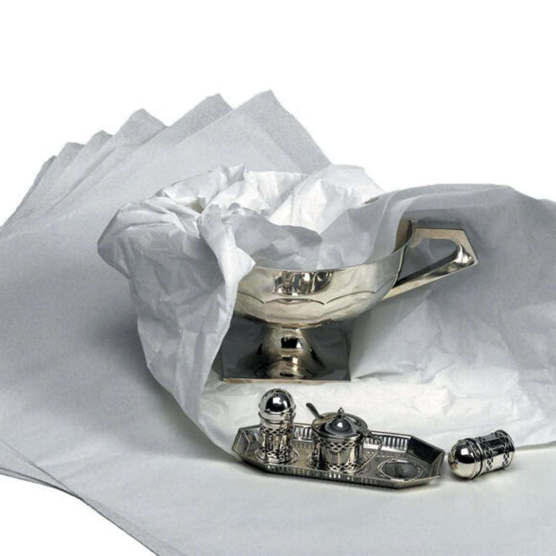 sheets of acidfree tissue paper wrapping silverware on a white background