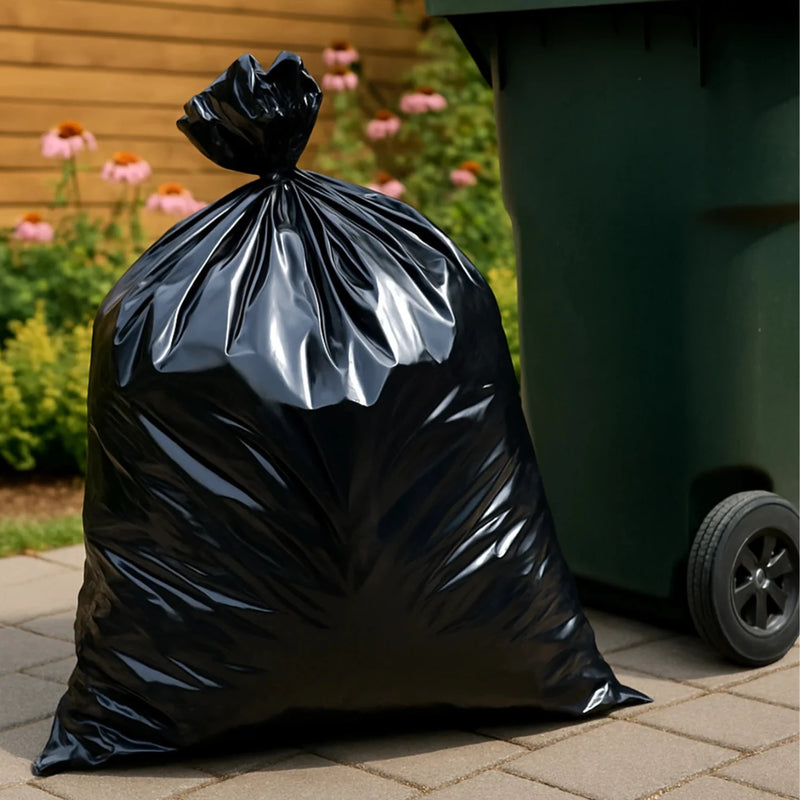 full black bin bag beside a green wheelie bin in a garden environment